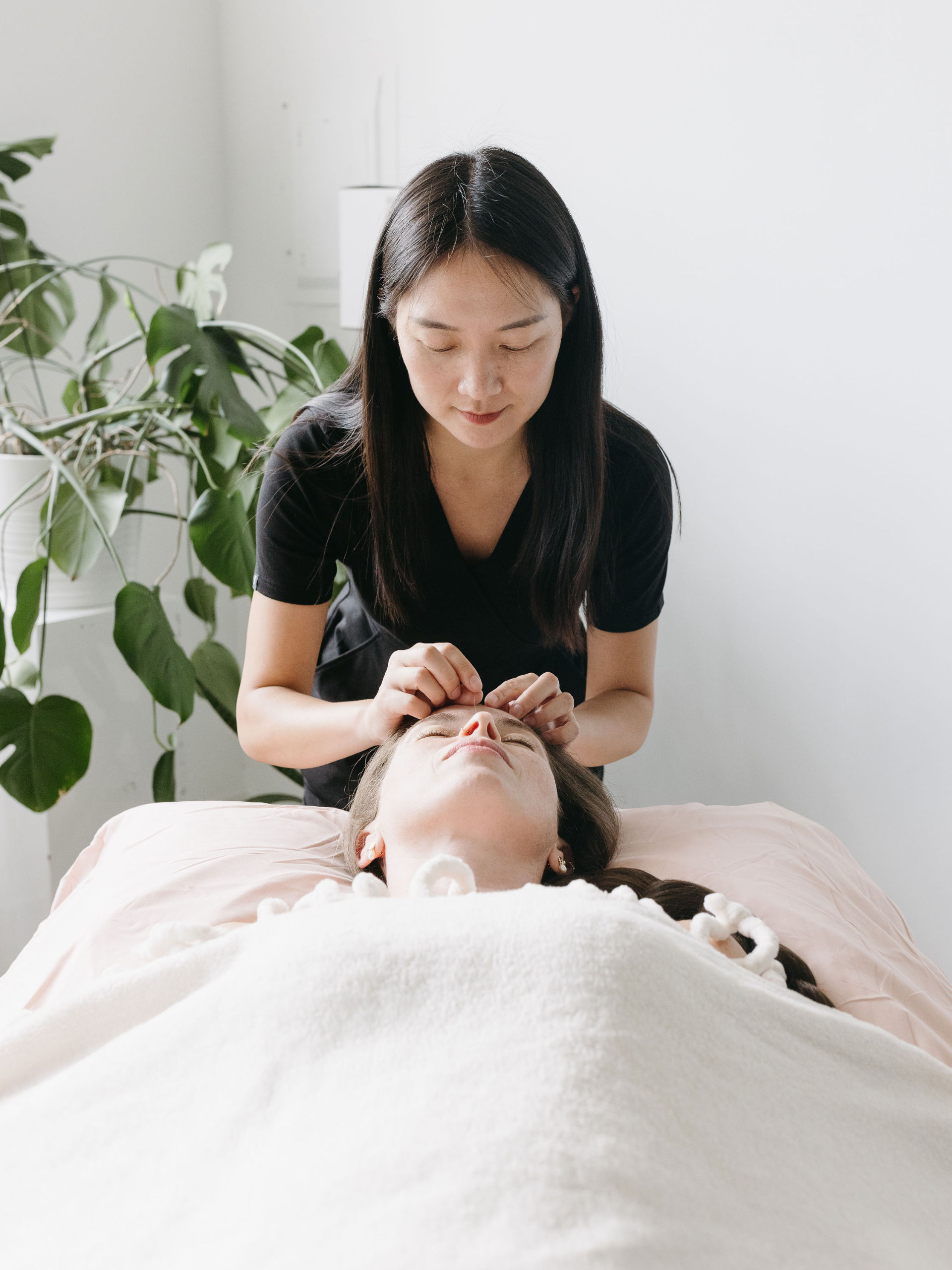 Women laying on her back receiving treatment at Cherry Blossom Healing Arts